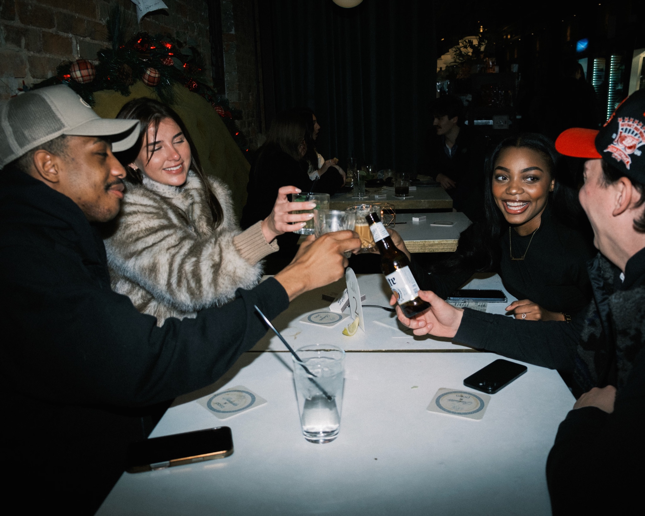 Four friends raising drinks on a double date